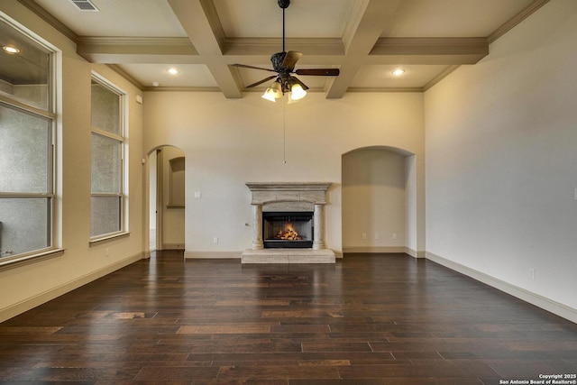 unfurnished living room featuring dark wood-type flooring, arched walkways, beamed ceiling, and a high end fireplace