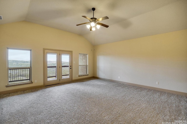 carpeted empty room featuring lofted ceiling, ceiling fan, visible vents, and baseboards