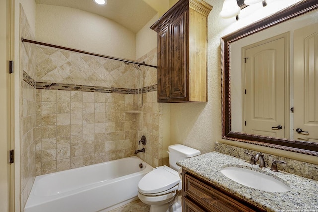 full bath featuring washtub / shower combination, a textured wall, toilet, and vanity