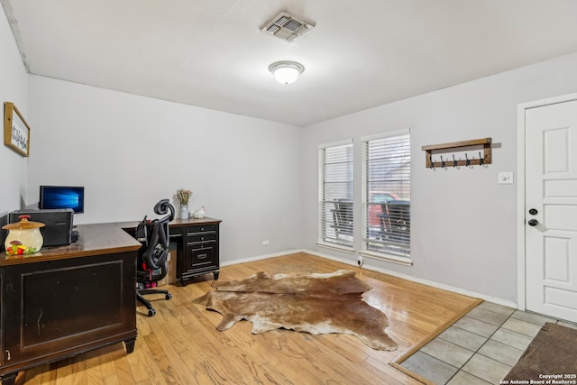 home office featuring wood finished floors, visible vents, and baseboards