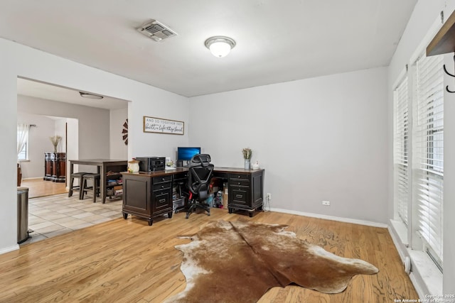 office featuring baseboards, visible vents, and wood finished floors