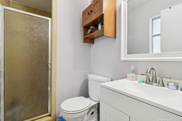 bathroom with toilet, a stall shower, and vanity