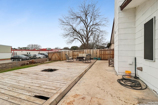 deck featuring an outdoor fire pit and a fenced backyard