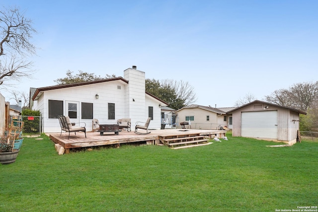 rear view of property with an outbuilding, a lawn, fence, and a wooden deck