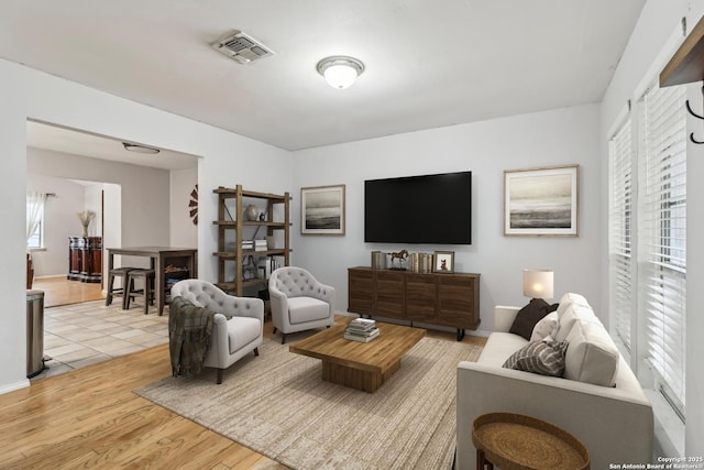 living room with light wood-type flooring and visible vents