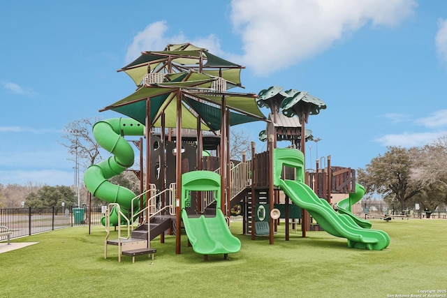 community play area featuring a lawn and fence