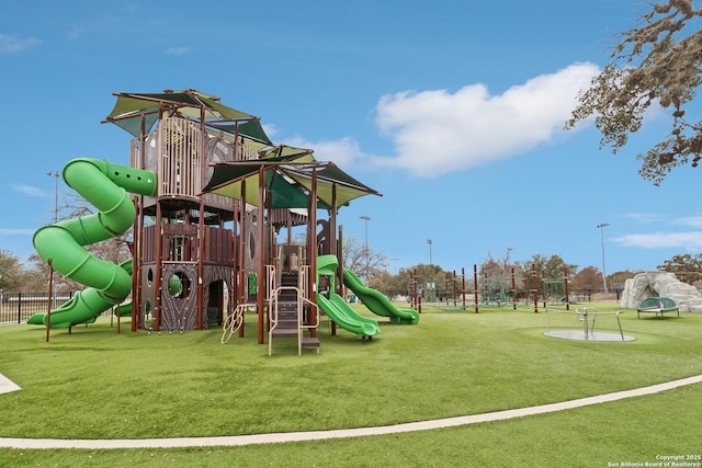 community playground featuring a lawn and fence