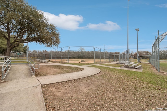 view of property's community with a lawn, fence, and a garden