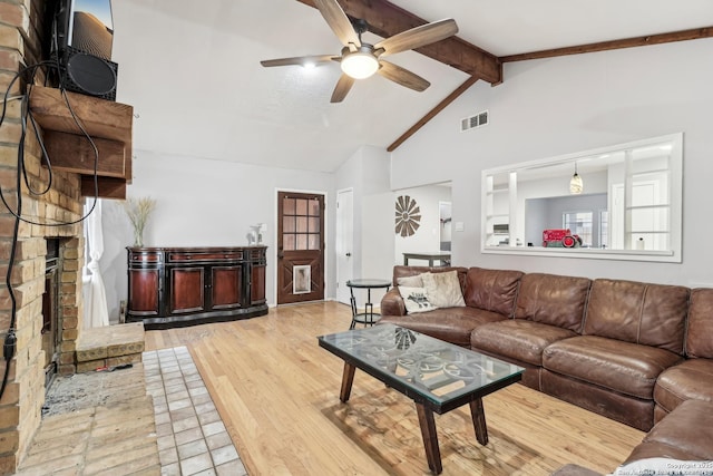 living room featuring lofted ceiling with beams, wood finished floors, visible vents, and a ceiling fan