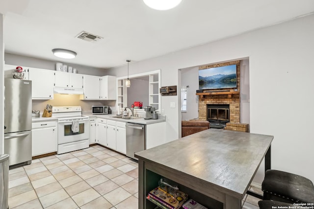 kitchen featuring stainless steel appliances, visible vents, white cabinetry, a sink, and under cabinet range hood