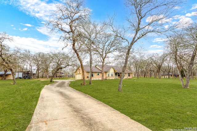 surrounding community featuring concrete driveway, a lawn, and an attached garage