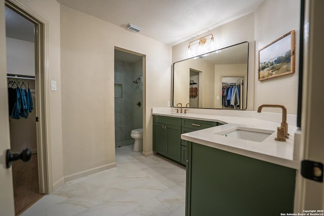 full bath featuring baseboards, tiled shower, marble finish floor, a textured ceiling, and vanity