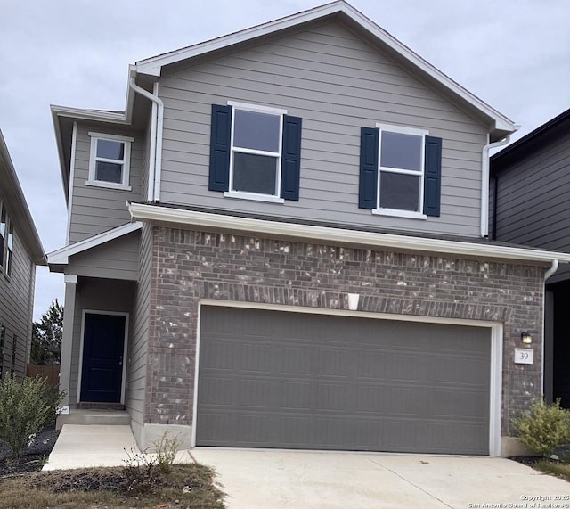 traditional home featuring concrete driveway, brick siding, and an attached garage