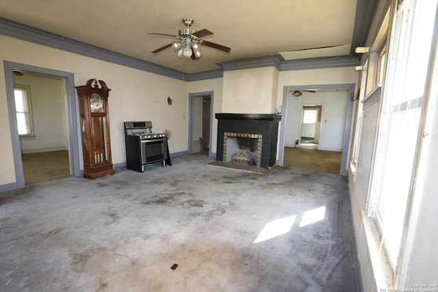 unfurnished living room featuring ceiling fan, a brick fireplace, baseboards, and crown molding