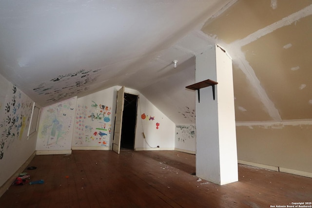 additional living space featuring vaulted ceiling, baseboards, and wood finished floors