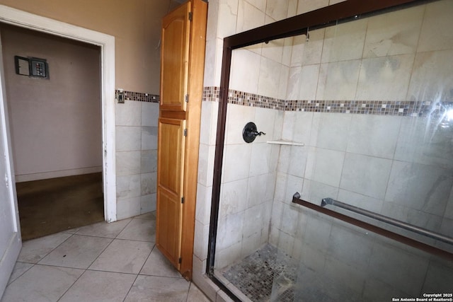 bathroom with a stall shower, tile walls, and tile patterned floors