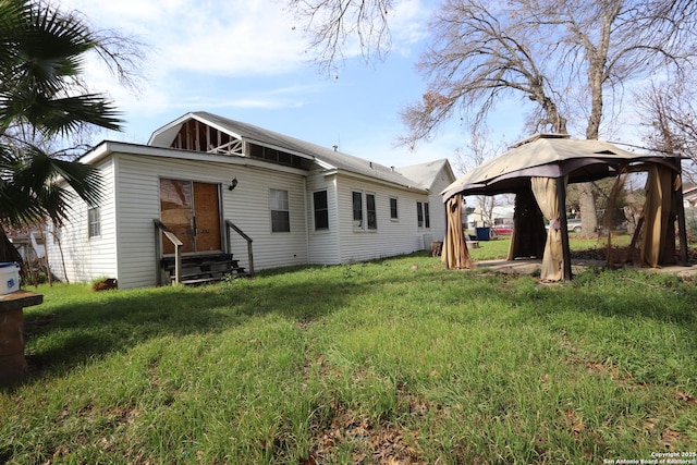 back of house featuring entry steps, a yard, and a gazebo