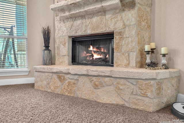 interior details featuring carpet and a stone fireplace