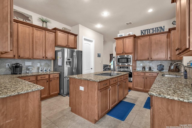 kitchen with stainless steel appliances, brown cabinets, and a sink