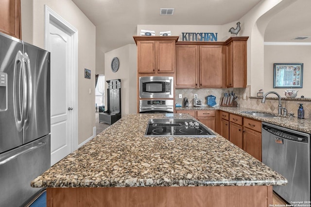 kitchen featuring a sink, visible vents, appliances with stainless steel finishes, backsplash, and dark stone counters