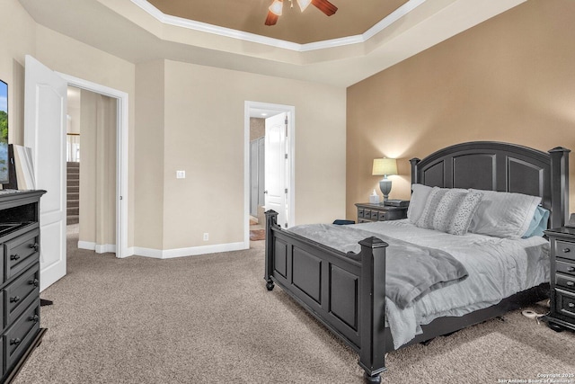 carpeted bedroom featuring ornamental molding, a tray ceiling, a ceiling fan, and baseboards