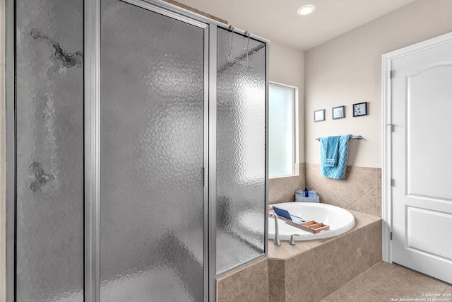 bathroom featuring tile patterned flooring, a shower stall, and a bath