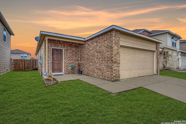 view of front of house featuring a garage, brick siding, fence, concrete driveway, and a front lawn