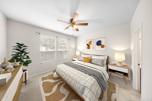 bedroom with light carpet, baseboards, and a ceiling fan