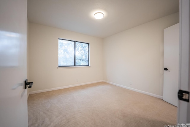 unfurnished room featuring baseboards and light colored carpet