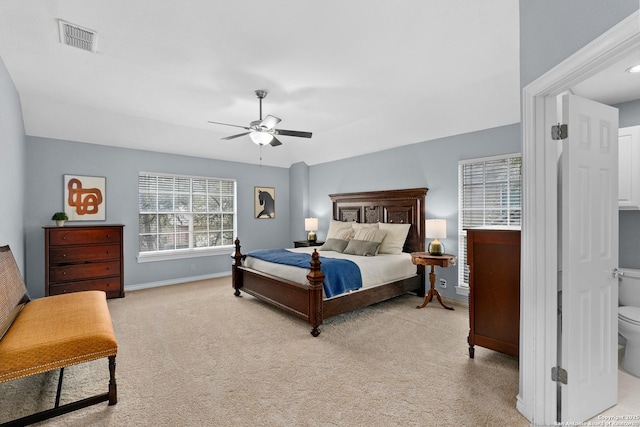 bedroom with light carpet, a ceiling fan, visible vents, and baseboards