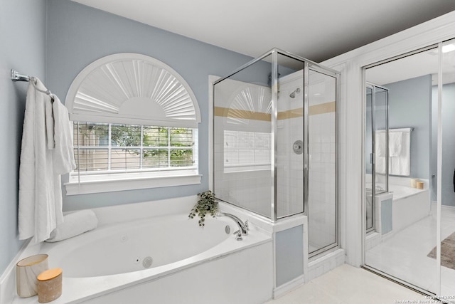 bathroom with a stall shower, a bath, and tile patterned floors