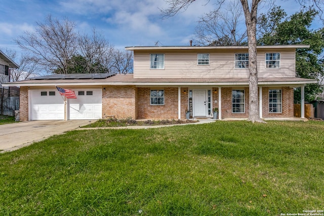 traditional-style house featuring a garage, solar panels, brick siding, driveway, and a front yard