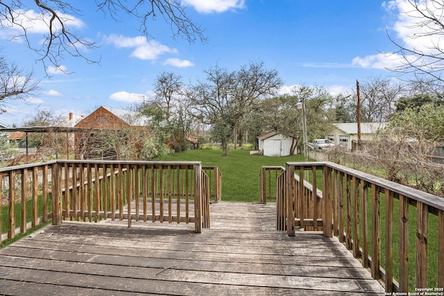 deck with an outbuilding, a storage unit, and a lawn