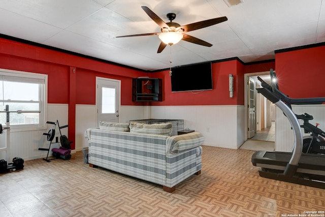 interior space featuring a wainscoted wall and a ceiling fan