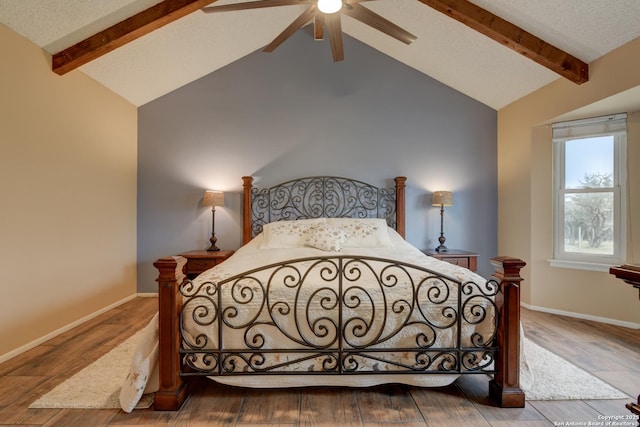 bedroom with lofted ceiling with beams, baseboards, and wood finished floors