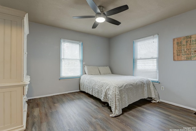 bedroom featuring a ceiling fan, baseboards, and dark wood-type flooring