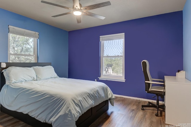 bedroom featuring dark wood finished floors, a ceiling fan, and baseboards