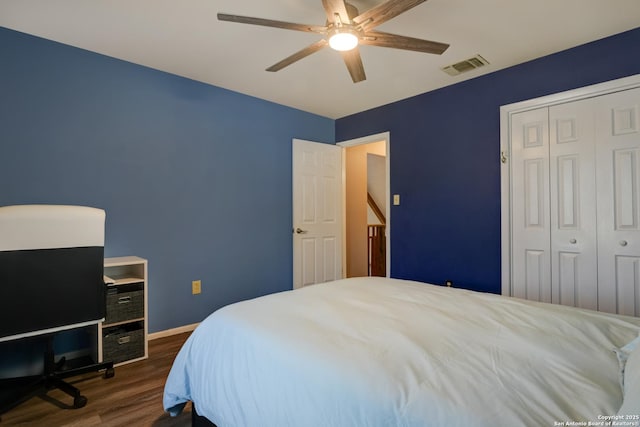 bedroom featuring ceiling fan, dark wood-style flooring, visible vents, baseboards, and a closet