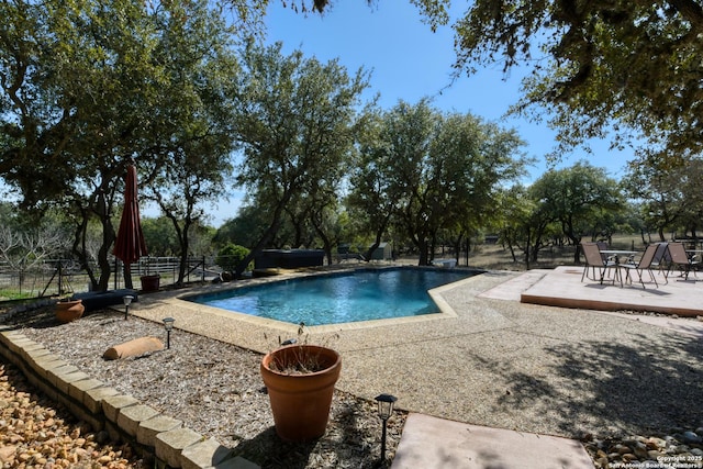 outdoor pool with a patio area and fence