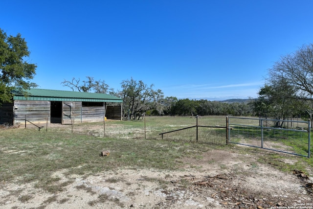 view of yard featuring an outbuilding, a rural view, and an exterior structure