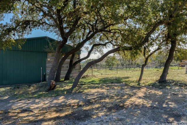 view of yard featuring fence, an outdoor structure, and an outbuilding