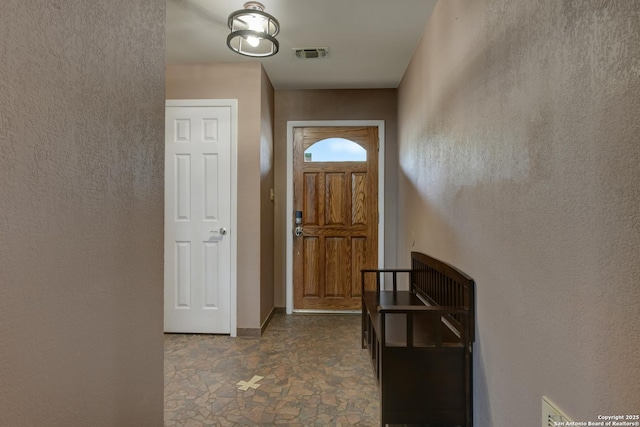 entryway with stone finish floor, visible vents, and baseboards