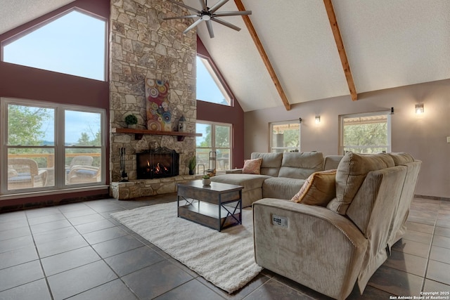 living room with a textured ceiling, high vaulted ceiling, a stone fireplace, and beamed ceiling