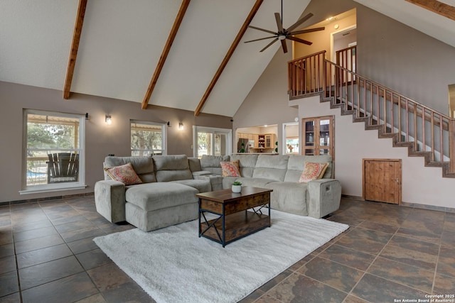 living area with high vaulted ceiling, stairway, plenty of natural light, and beam ceiling