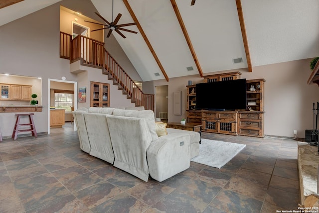 living area featuring stone finish floor, stairway, visible vents, and a ceiling fan