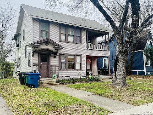 view of front of property featuring a front yard and a balcony