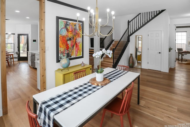 dining area featuring stairway, recessed lighting, wood finished floors, and a notable chandelier