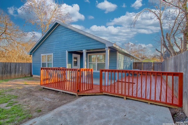 rear view of house featuring a fenced backyard and a deck