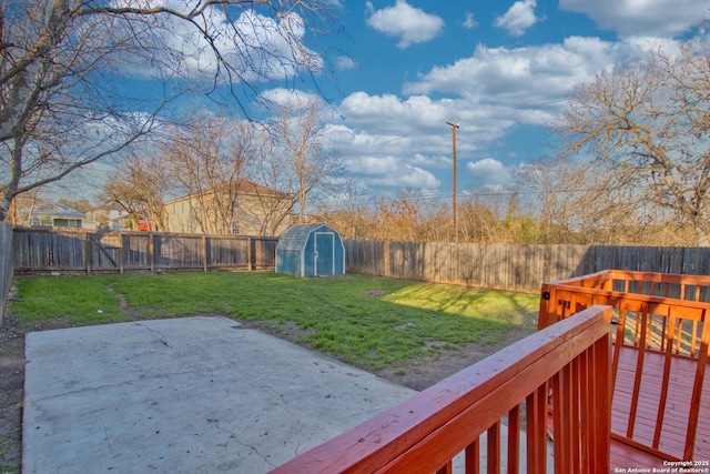 view of yard with an outdoor structure, a fenced backyard, a patio, and a storage shed