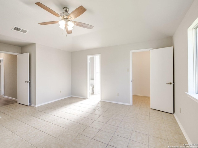 unfurnished bedroom featuring light tile patterned floors, baseboards, visible vents, and ceiling fan